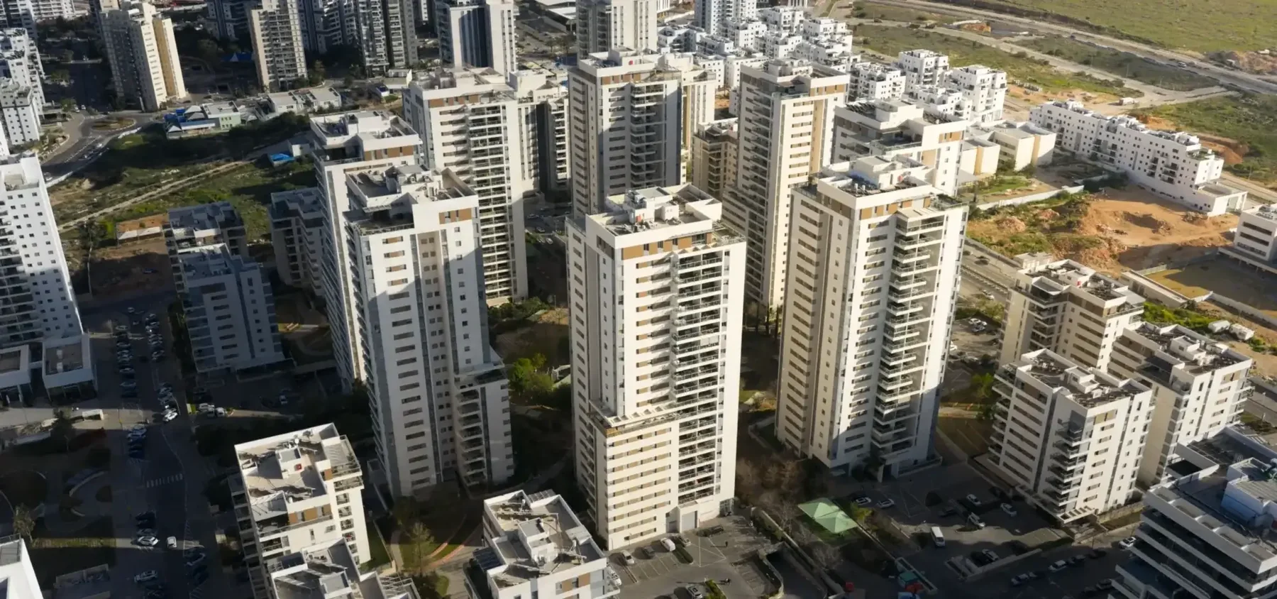 צילום רחפן: מגדלי מגורים לבנים בשכונה חדשה, מזווית אלכסונית