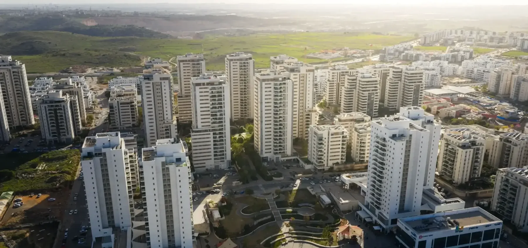צילום רחפן: מגדלי מגורים, ובמרחק גבעות ירוקות