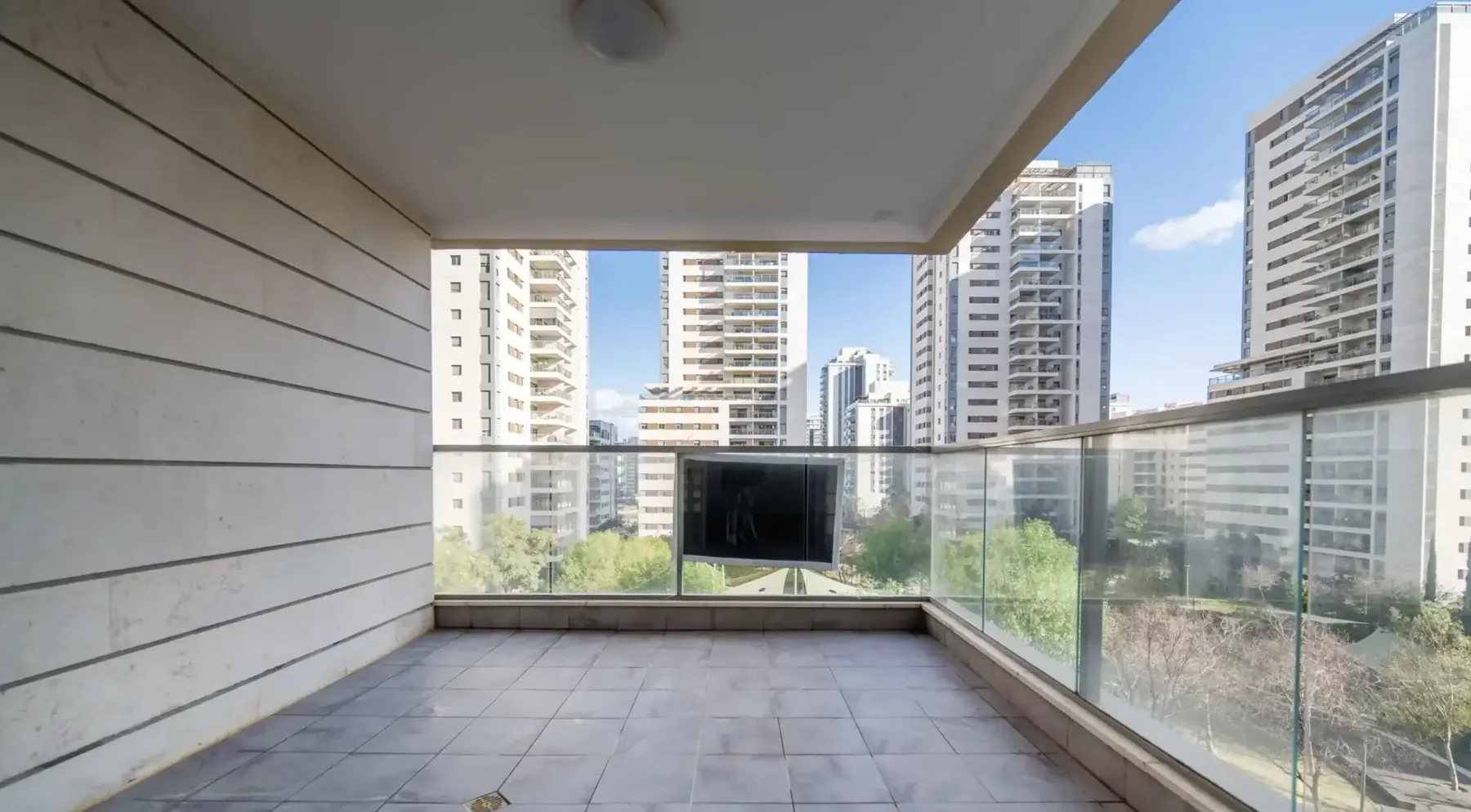 מרפסת עם מעקה זכוכית ונוף למגדלי מגורים