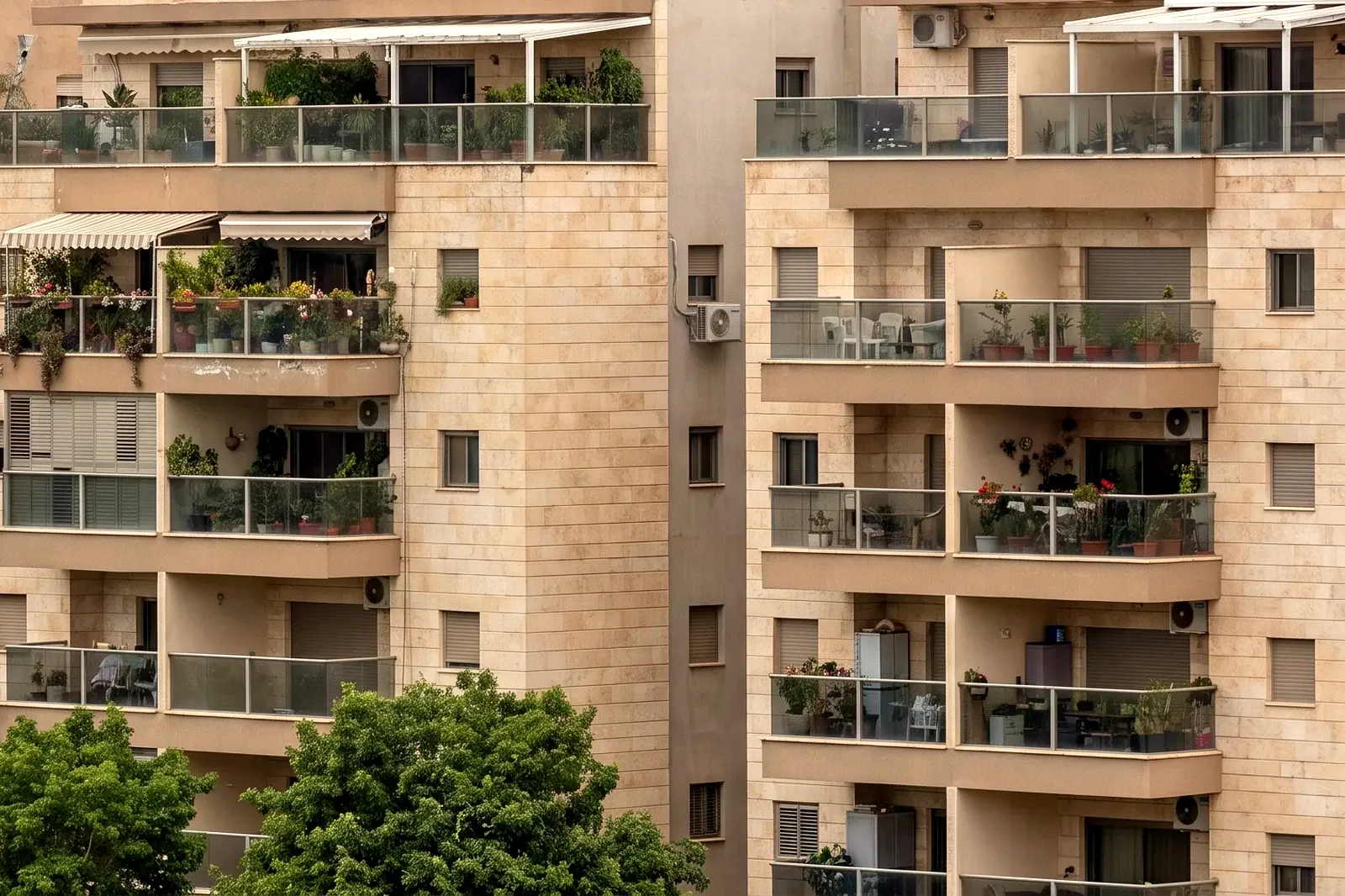 הדמיה: חזיתות מרפסות של בנייני מגורים מטופחים בצילום טלה מקרוב, עם עציצים ומזגנים