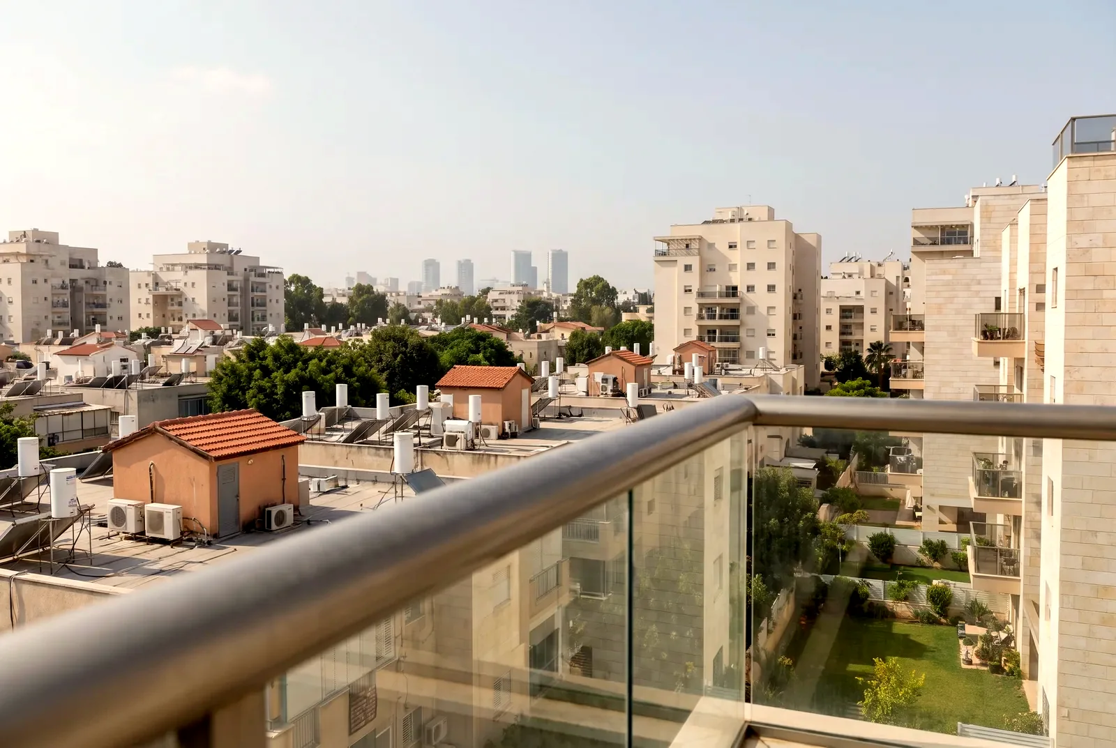 הדמיה: מבט ממרפסת על גגות שכונת מגורים ועל מגדלים רחוקים בערפל