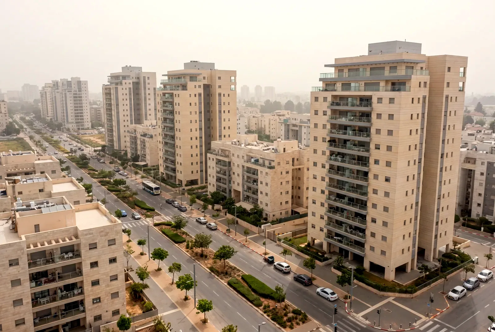 הדמיה: מבט מהאוויר באלכסון על שכונה חדשה עם שדרה מגוננת ומגדלי מגורים בין בנייני אבן נמוכים יותר.