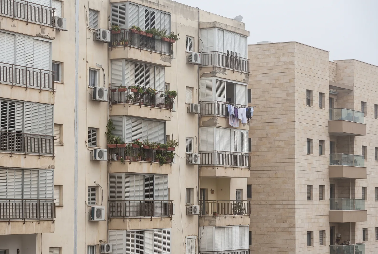 הדמיה: חזיתות של בנייני מגורים עם מרפסות, בניין ותיק לצד בניין חדש