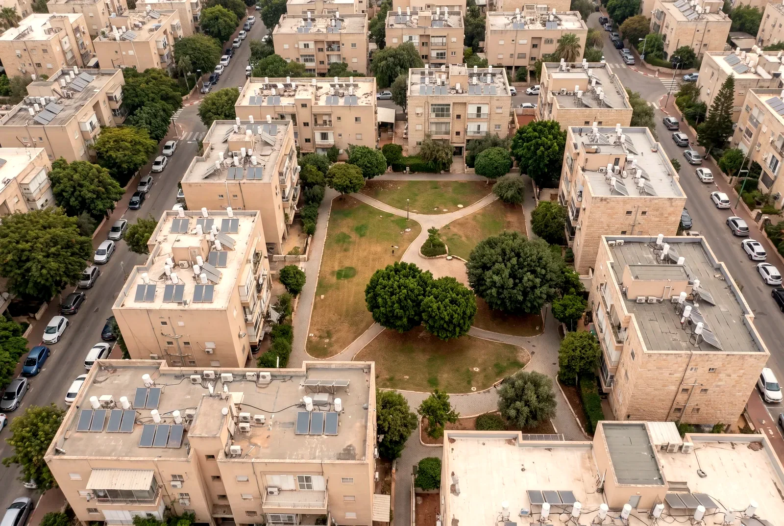 הדמיה: מבט ישר מלמעלה מרחפן על בנייני מגורים, רחובות ופארק שכונתי.