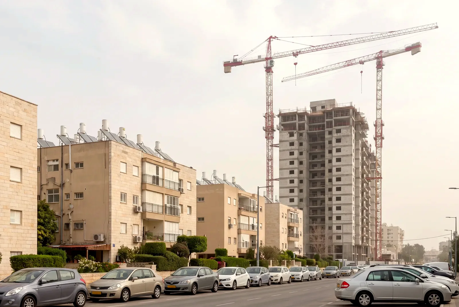 הדמיה: אתר בנייה עם שני עגורני מגדל ושלד של מגדל חדש ליד בנייני מגורים ותיקים ומטופחים