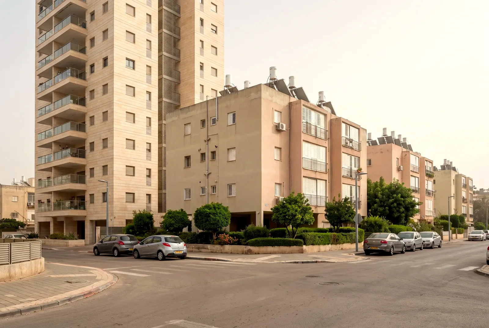 הדמיה: מגדל מגורים חדש בחיפוי אבן לצד בנייני מגורים ותיקים ומטופחים