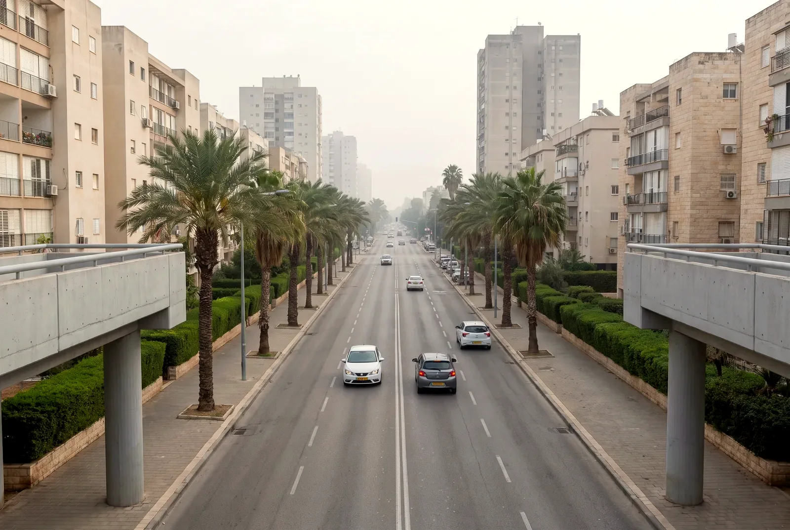 הדמיה: מבט מגשר הולכי רגל לאורך כביש ראשי עם תנועה קלה ובנייני מגורים משני צדיו.
