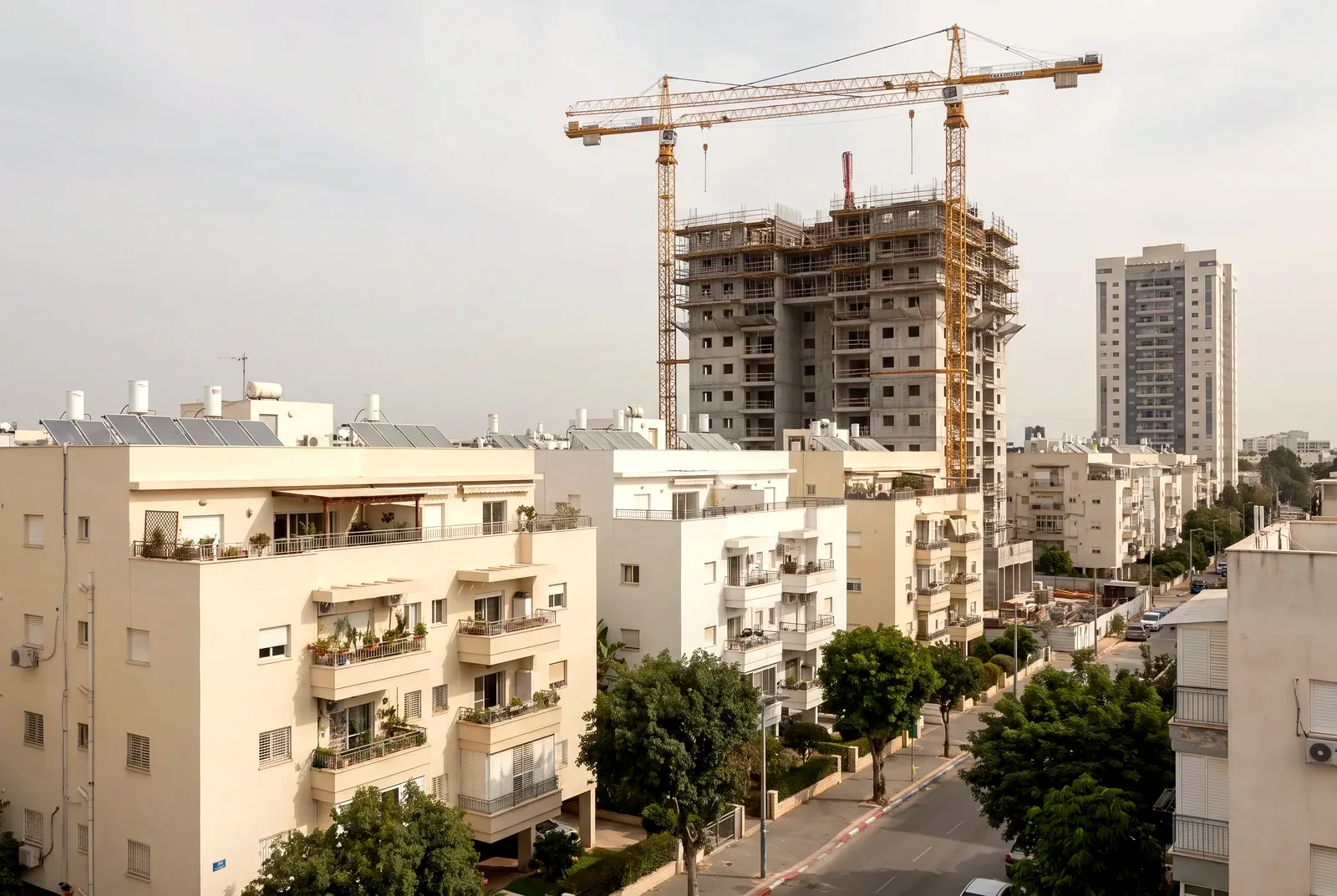 הדמיה: אתר בנייה של התחדשות עירונית עם שני מנופי צריח ליד בנייני מגורים ותיקים ומסוידים