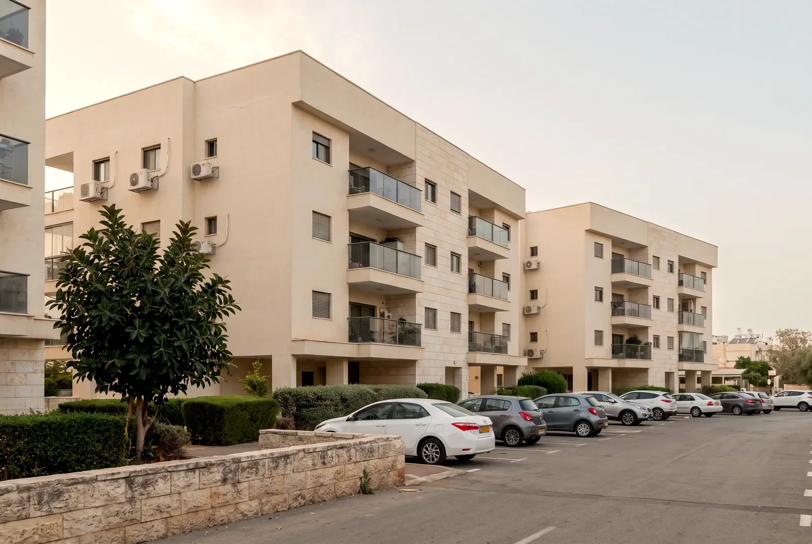 הדמיה: שני בנייני מגורים מטופחים זה לצד זה מעל חניה קטנה עם מכוניות חונות