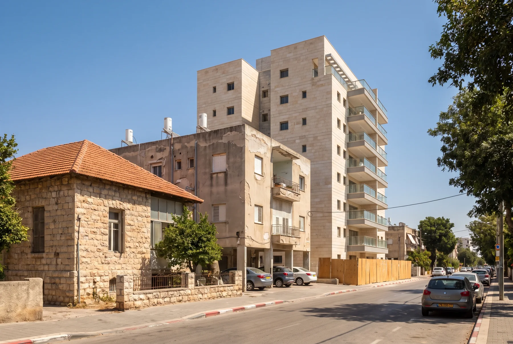 הדמיה: בית ותיק עם גג רעפים ובניין ישן, ולצדם בניין מגורים חדש