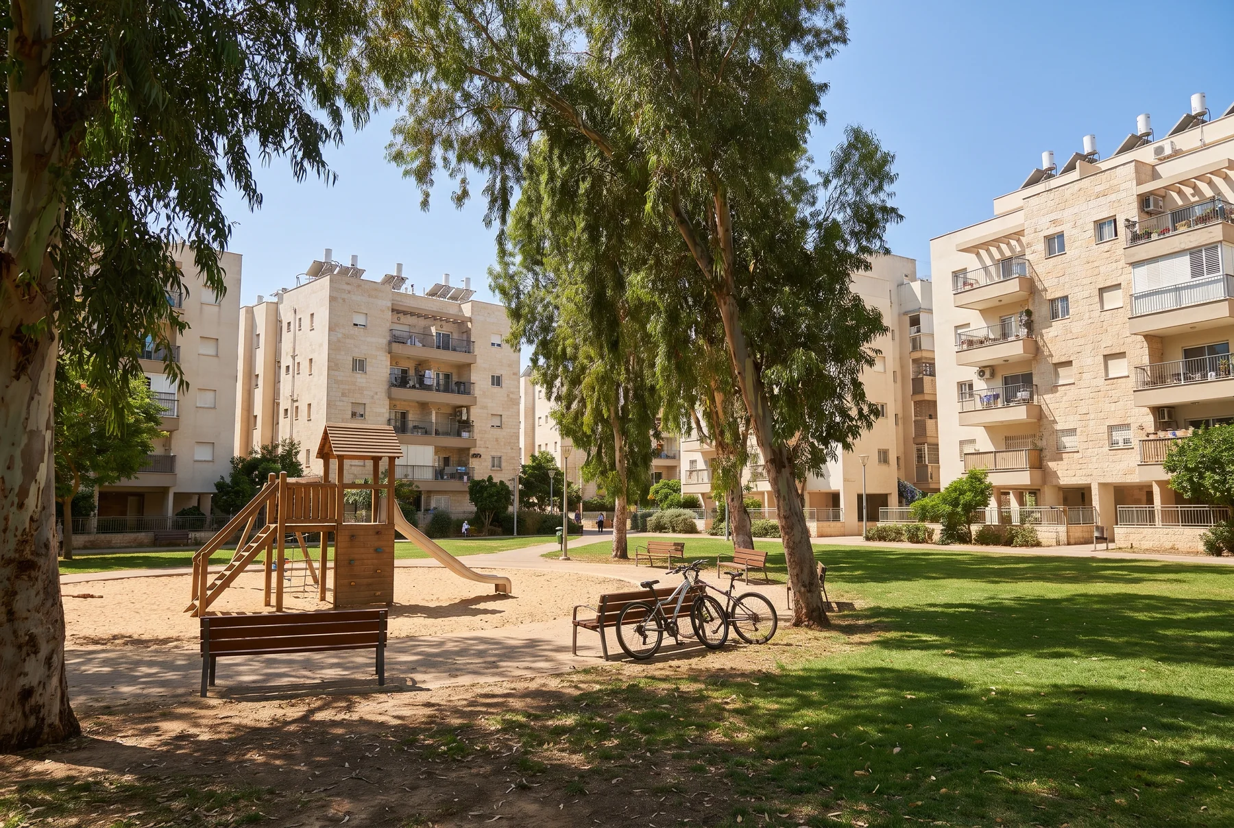 הדמיה: גינה שכונתית עם מתקן משחקים וספסלים בין בנייני מגורים